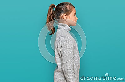 Little beautiful girl wearing casual turtleneck sweater looking to side, relax profile pose with natural face with confident smile Stock Photo