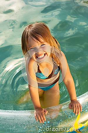 Little beautiful smiling girl in swimming pool. Stock Photo