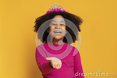 Little black girl in princess crown sending air kiss at camera Stock Photo