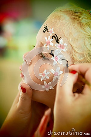 Little blond blue eyed girl face painting Stock Photo