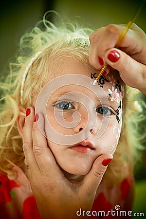 Little blond blue eyed girl face painting Stock Photo