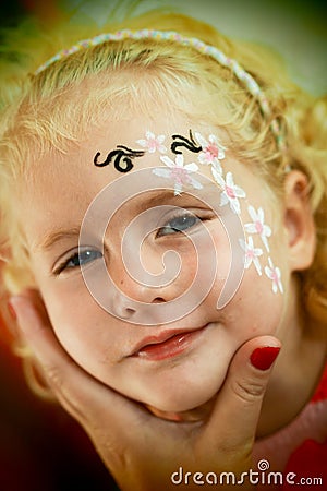 Little blond blue eyed girl face painting is smiling Stock Photo
