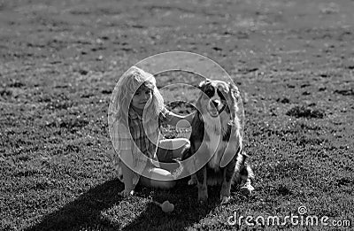 Little blond boy with her pet dog outdooors in park. Cute child with a puppy dog, outdoor summer. A child with a dog Stock Photo