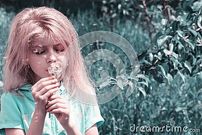 Little blond girl blowing dandelion Stock Photo