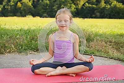 Little blond girl doing fitness exercises plank in the park Stock Photo