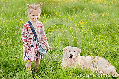 A little girl with her pet dog outdooors in park Stock Photo