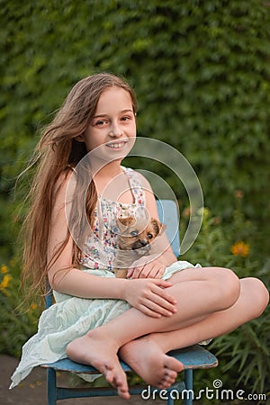 A little blond girl with her pet dog outdooors in park Stock Photo