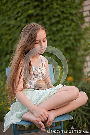 A little blond girl with her pet dog outdooors in park Stock Photo