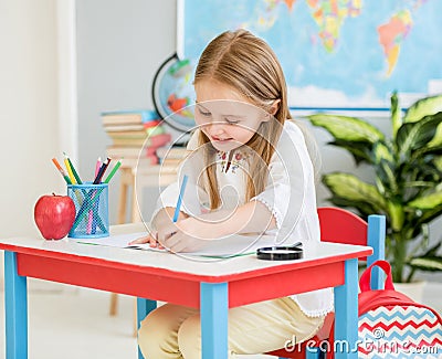 Little blond girl writing classwork in the school classroom Stock Photo