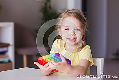 Little blonde girl children play with new trend sensory toy Stock Photo