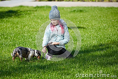 Little blonde girl and a loving puppy dachshund Stock Photo