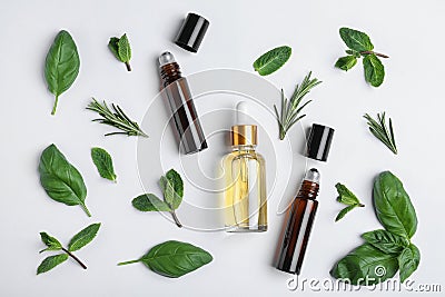 Little bottles of essential oils with different herbs on white background Stock Photo