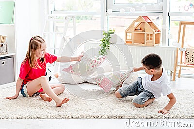 Little boy ang girl fighting pillows Stock Photo