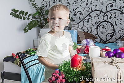 A little boy in anticipation of Christmas and New year, playing with Christmas decorations. Witing for a miracle Stock Photo