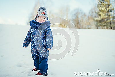 little boy in a blue jacket in a snowy forest crying on a cold day Stock Photo
