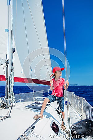 Little boy on board of sailing yacht on summer cruise. Travel adventure, yachting with child on family vacation. Stock Photo