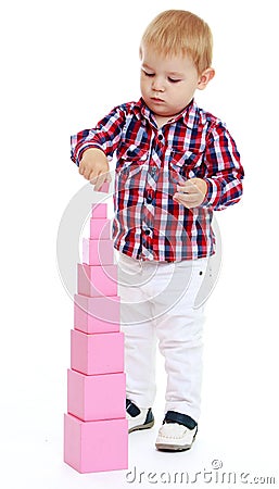 Little boy builds Red Pyramid, Montessori Stock Photo