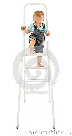 Little boy climbing up on ladder Stock Photo