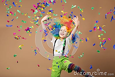 Little boy in clown wig jumping and having fun celebrating birth Stock Photo