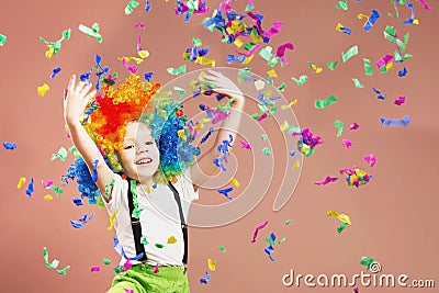 Little boy in clown wig jumping and having fun celebrating birth Stock Photo