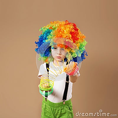 Little boy in clown wig playing with a spring. Editorial Stock Photo