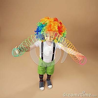 Little boy in clown wig playing with a spring Editorial Stock Photo