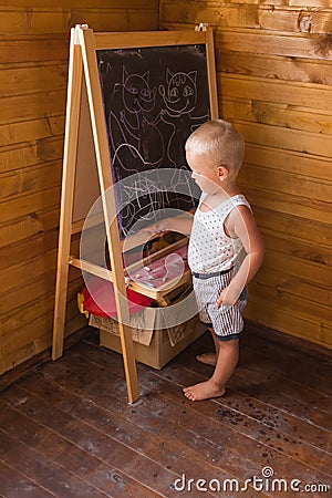 Little boy drawing with chalk on a blackboard Stock Photo