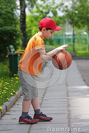 Little boy dribbling basketball sideview Stock Photo