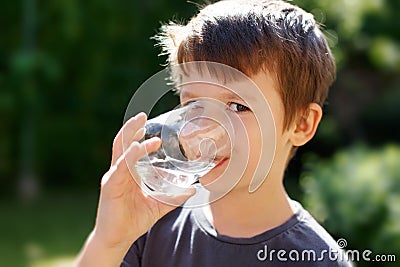 Little boy drink water in nature Stock Photo