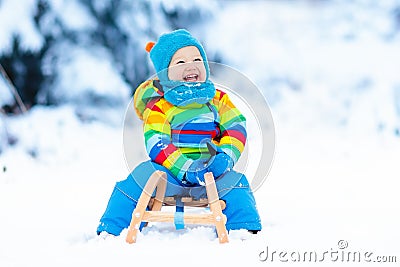 Boy on sleigh ride. Child sledding. Kid with sledge Stock Photo