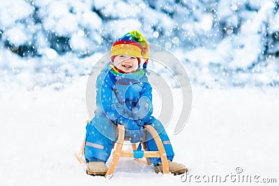 Boy on sleigh ride. Child sledding. Kid with sledge Stock Photo