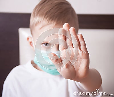 Little boy in face mask showing stop sign with her hand Stock Photo