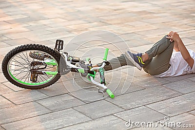 Little boy fallen off his bicycle on stree Stock Photo