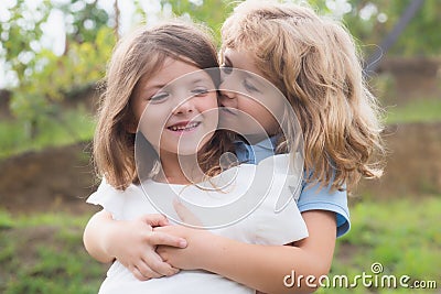 Little boy and girl best friends hugging. Kids kissing each other with love at summer park. Happy kids couple in love Stock Photo