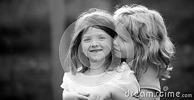 Little boy and girl best friends hugging. Kids kissing each other with love at summer park. Happy kids couple in love Stock Photo