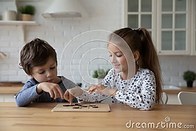 Little boy and girl playing wooden educational game, checkers Stock Photo