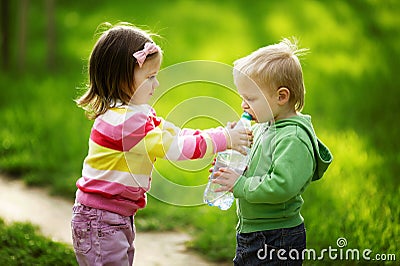 Little boy and girl sharing bottle of water Stock Photo