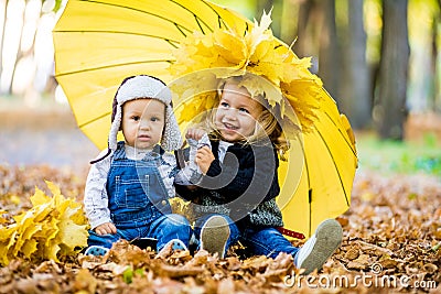 Little boy with a girl under an umbrella from the rain autumn Stock Photo