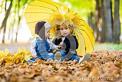 Little boy with a girl under an umbrella from the rain autumn Stock Photo