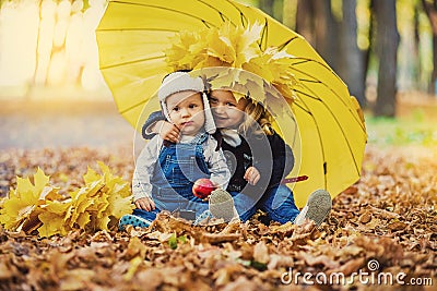 Little boy with a girl under an umbrella from the rain autumn Stock Photo