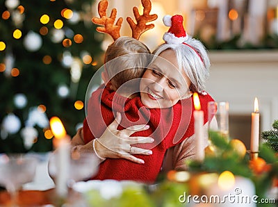 Little boy grandson embracing happy smiling grandmother during Christmas dinner at home Stock Photo