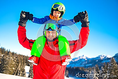 Little boy having fun with his caucasian attractive father during skiing in Alps. Stock Photo