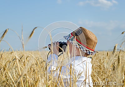 Little boy hiding in a wheat field bird watching Stock Photo