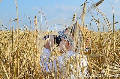 Little boy hiding in a wheat field bird watching Stock Photo