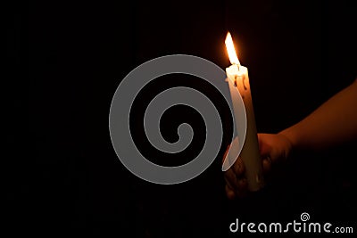 Little boy holding a candle in the dark ,faith and religion ,prayer Stock Photo