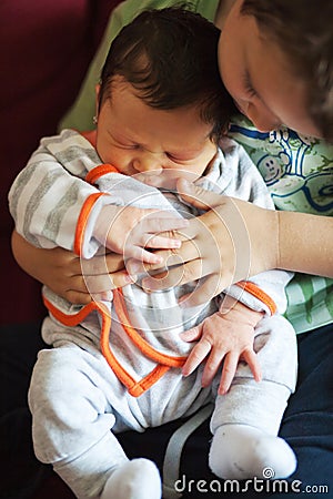 Little boy holding and caressing his sister Stock Photo