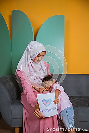 Little boy holding a paper love drawing for mom Stock Photo