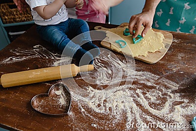 Little boy in jeans mixing flour in the kitchen on a table making some mess Stock Photo