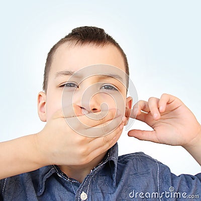 Little boy, kid covered his mouth with his palm, bit his tongue, stomatitis, clings to his ear, close-up, medical concept, autism Stock Photo
