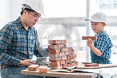 Little boy learning how to lay down brick work from his builder father in vintage tone Stock Photo